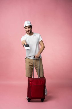 Bavulu, pasaportu ve arka planda bileti olan bir adam..