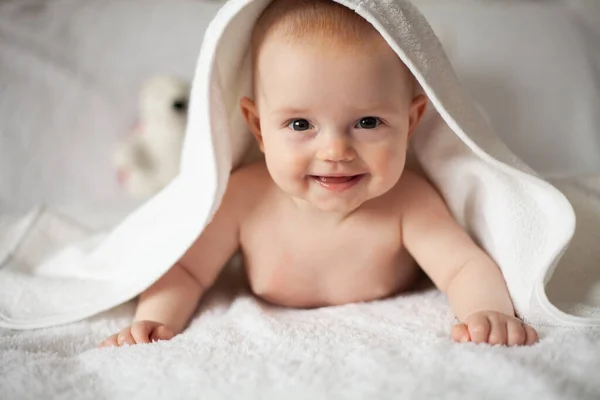 Mädchen versteckt sich unter der weißen Decke. — Stockfoto