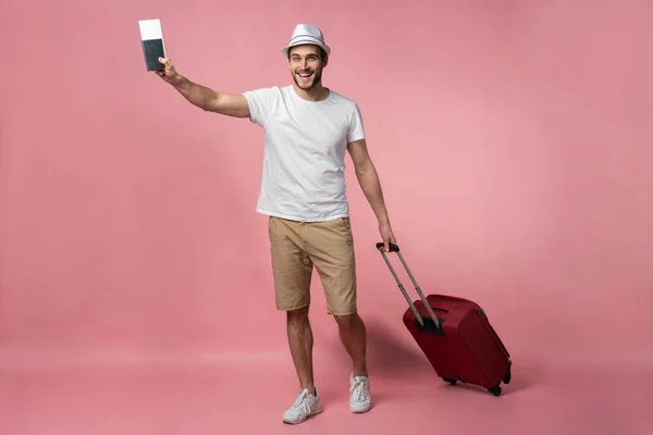 Podróżujący mężczyzna z walizką, paszportem i biletem na tle koloru. — Zdjęcie stockowe