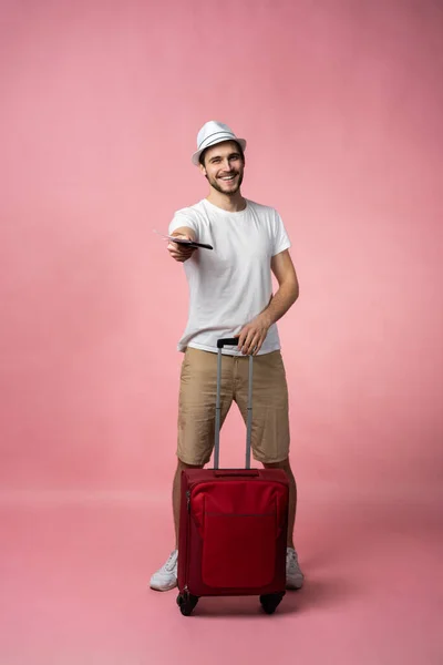 スーツケース、パスポート、チケットを持つ男性旅行者の色の背景. — ストック写真
