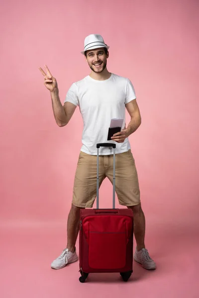 Homem viajante com mala, passaporte e bilhete sobre fundo de cor. — Fotografia de Stock