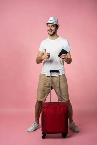 Homme voyageur avec valise, passeport et billet sur fond de couleur. — Photo