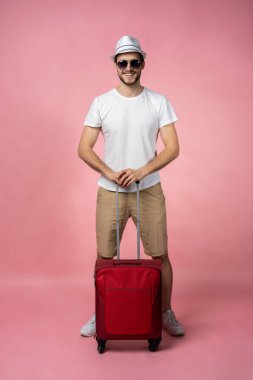 Bavulu, pasaportu ve arka planda bileti olan bir adam..