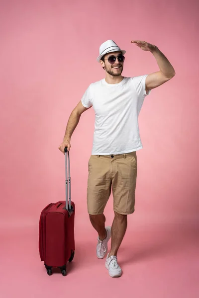 Man traveler with suitcase, passport and ticket on color background.