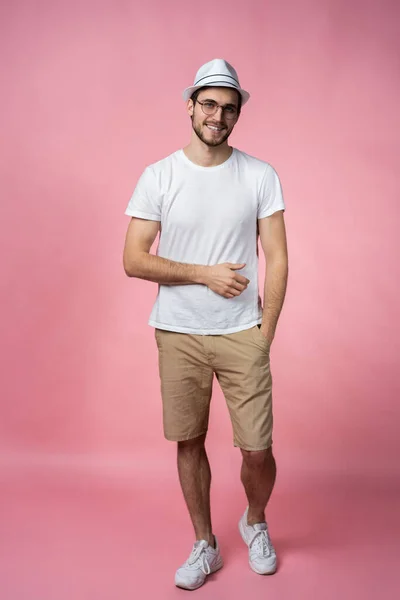 Cheerful hipster guy smiles happily, has excited expression, dresssed casually isolated over pink studio background. People, youth, emotions concept. — Stock Photo, Image