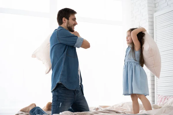 아침에 침대에서 베개 싸움을 하는 행복 한 아버지와 딸 — 스톡 사진