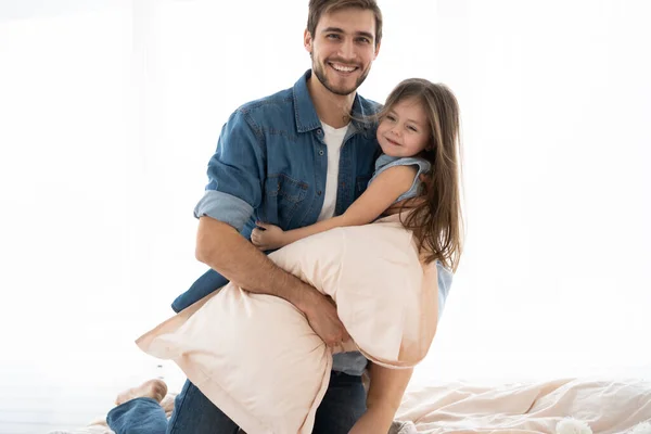 Felice padre e figlia a giocare a cuscino lotta a letto al mattino — Foto Stock