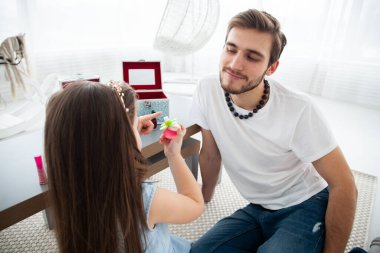 Sevimli küçük kızı ve taçlı yakışıklı genç babası Childs 'ın odasında birlikte oynuyorlar. Kız babasına makyaj yapıyor..