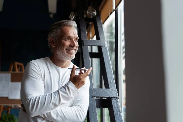 Casual grijze haren volwassen zakenman praten op een mobiele telefoon staan bij het raam. — Stockfoto