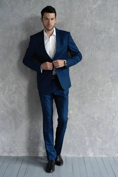 Pełna długość przystojny mężczyzna nosić niebieski garnitur izolowane na szarym tle. — Zdjęcie stockowe