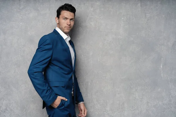 Handsome man wear blue suit isolated on grey background. — Stock Photo, Image