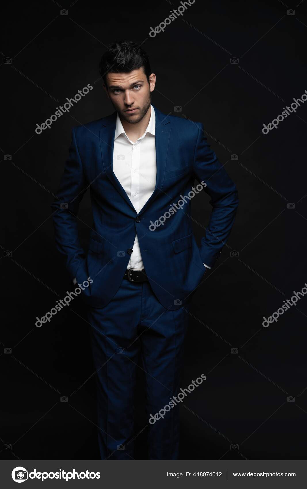 Handsome man wear blue suit isolated on black background. Stock Photo