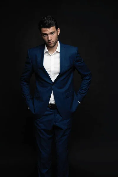 Handsome man wear blue suit isolated on black background.