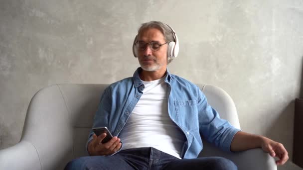 Caucasiano de cabelos grisalhos Maduro homem ouvindo música em fones de ouvido — Vídeo de Stock