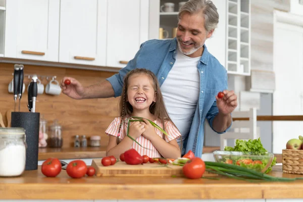 Şirin küçük kız ve yakışıklı babası evde yemek pişirirken eğleniyorlar.. — Stok fotoğraf