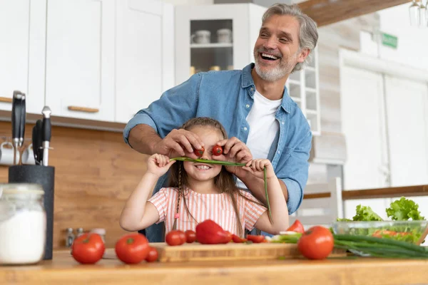 Linda niña y su padre guapo se divierten mientras cocinan en la cocina en casa. — Foto de Stock