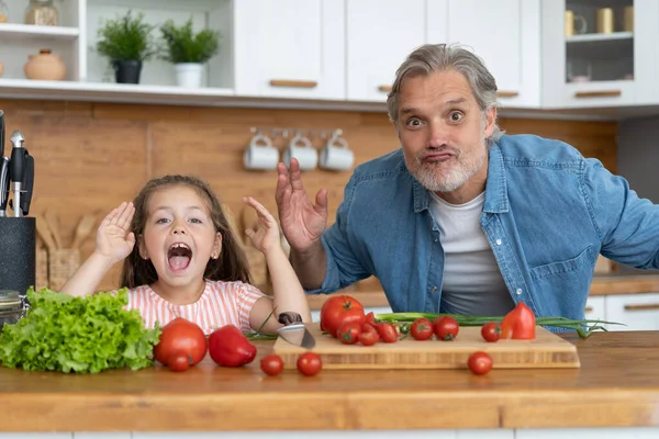 Carino bambina e il suo bel papà si stanno divertendo mentre cucina in cucina a casa. — Foto Stock