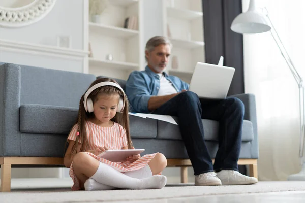 Father and daughter using electronic devices at home. — Stock Photo, Image