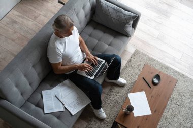 Ev ofisinden bilgisayarda çalışan orta yaşlı bir adam..