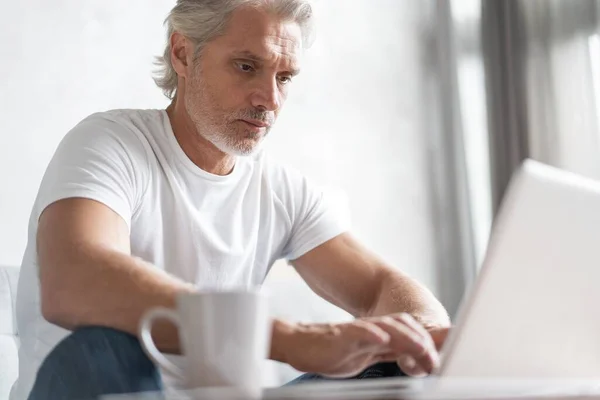 Hombre de mediana edad que trabaja desde casa-oficina en el ordenador portátil. —  Fotos de Stock