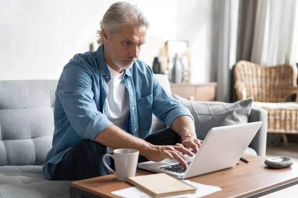 Hombre de mediana edad que trabaja desde casa-oficina en el ordenador portátil. — Foto de Stock