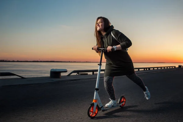 Mujer alegre montando un patinete scooter — Foto de Stock