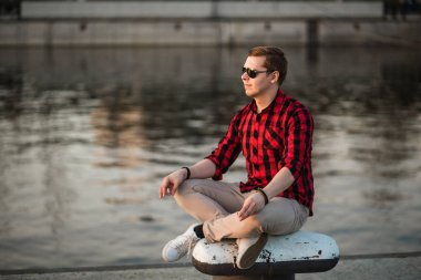 Lotus pozisyonu şehir setin içinde oturan ve ayarı güneşe bakarak adam