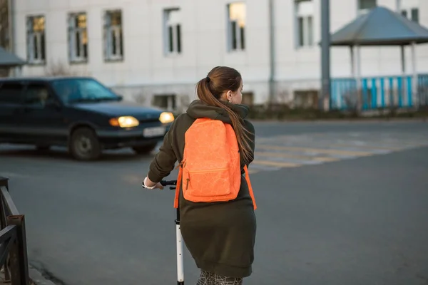 Kobieta z hulajnoga pokonywania ruchliwej ulicy wzdłuż przejście dla pieszych — Zdjęcie stockowe