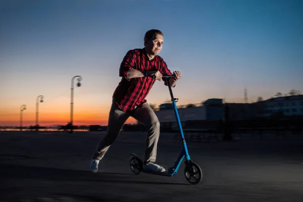 Junger Mann fährt nachts auf Motorroller. — Stockfoto