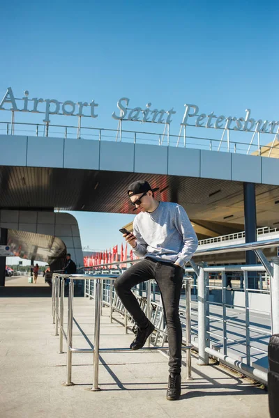 Homme élégant voyageur utilisant un smartphone pour appeler un taxi de l'aéroport Pulkovo à Saint-Pétersbourg — Photo