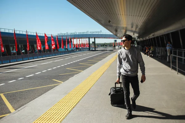 Человек путешественник с чемоданом выезд из терминала аэропорта — стоковое фото