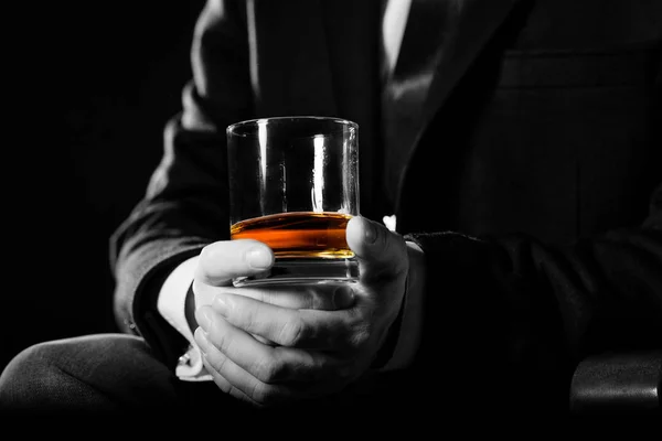 Zbliżenie poważnego biznesmena trzymającego whisky ilustruje koncepcję przywileju wykonawczego. — Zdjęcie stockowe