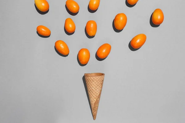 ส้มสด Kumquats และถ้วยวาฟเฟิลบนโต๊ะสีเทา การประกอบแบบแบน . — ภาพถ่ายสต็อก