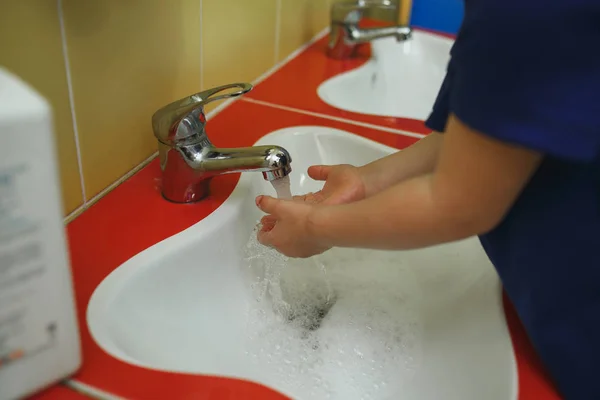 Anaokulunda banyoda sabunla el yıkama çocuk