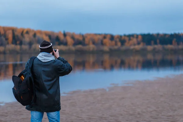Вид ззаду фотографа-аматора, що знімає осінні пейзажі річки. Ландшафтна терапія — стокове фото