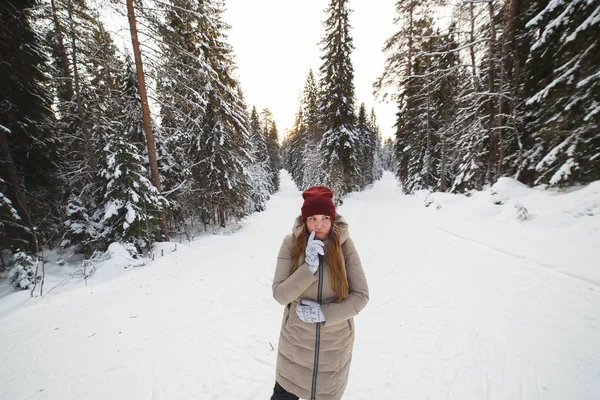 Jeune femme debout au carrefour de la forêt de pins d'hiver enneigée. Concept de choix des parcours — Photo