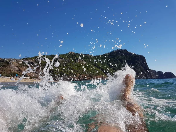 Spritzt mit männlichen und weiblichen Füßen. Konzept für den Urlaub am Meer — Stockfoto