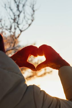 Kalp şekli kış soğuk günbatımı kadın eldivenler sembolü. Kış, dating, Sevgililer günü ve sevgi kavramı