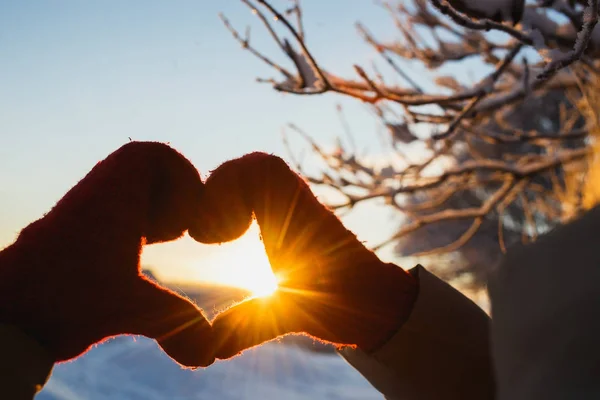 El símbolo de la forma del corazón de las mujeres mitones en invierno puesta de sol helada. Concepto de invierno, citas, día de San Valentín y amor — Foto de Stock