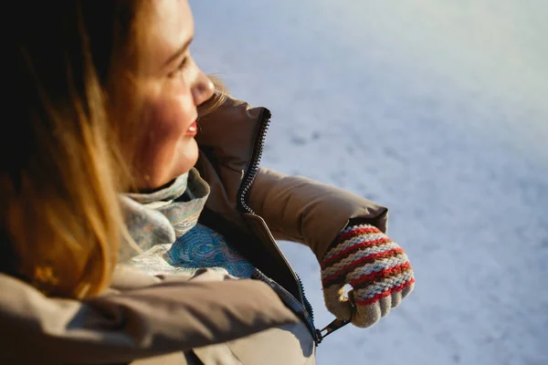 We warm. Vrouw ritsen van haar jasje op een zonnige winterdag — Stockfoto