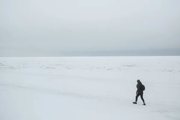 Один турист с рюкзаком отправляется на зимнее побережье. Минималистическая композиция — стоковое фото