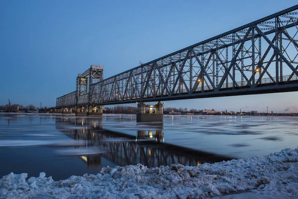 Belle vue sur la dérive des glaces sous le pont ferroviaire à Arkhangelsk, en Russie. Beau mouvement de glace sur la rivière Dvina Nord, paysage du soir — Photo