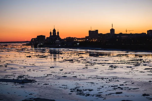 Ice drift i Norra Dvina-floden i Arkhangelsk, Ryssland. Vackra is motion kvällen siluett citiscape — Stockfoto