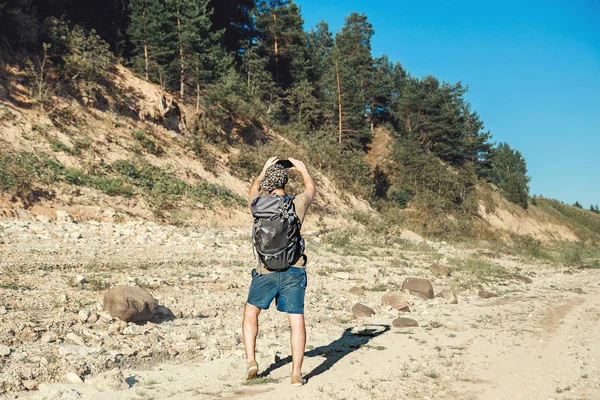 Męski turystyczny backpacker fotografowanie pięknych krajobrazów leśnych — Zdjęcie stockowe
