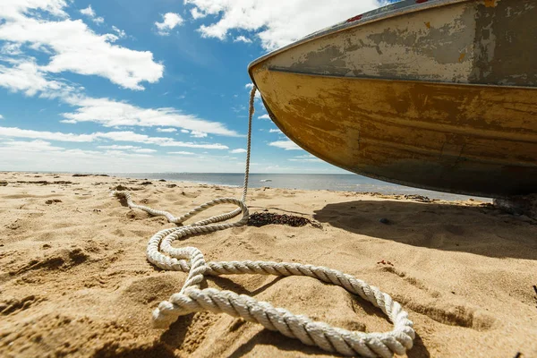 Old fishing boat with rope on a sandy beach — Stock Photo, Image