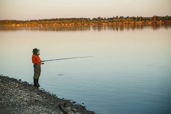 Mujer joven en la pesca de mosquiteros con caña de pescar en la noche — Foto de Stock