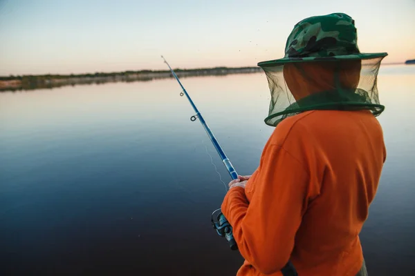 Mujer joven en la pesca de mosquiteros con caña de pescar en la noche — Foto de Stock