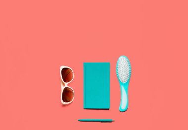 Son moda renkli düz kompozisyon yatıyordu. Turkuaz günlüğü, saç tarak, beyaz gözlük ve kalem ile mercan renkli resepsiyon. Minimalist yaşam mercan görüntü blogcular, tasarımcılar, dergi vb tonda