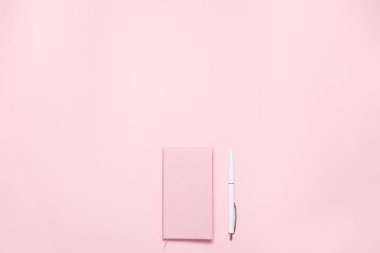 Pembe renkli günlüğü ve beyaz kalem ile pembe renkli resepsiyon. Minimalist düz blogcular, tasarımcılar, dergi vb kopya alanı ile kompozisyon yatıyordu