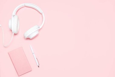Pembe günlüğü, beyaz kalem ve pembe masa üzerinde beyaz kulaklık. Üstten görünüm. Minimalist düz blogcular, tasarımcılar, dergi vb kopya alanı ile kompozisyon yatıyordu